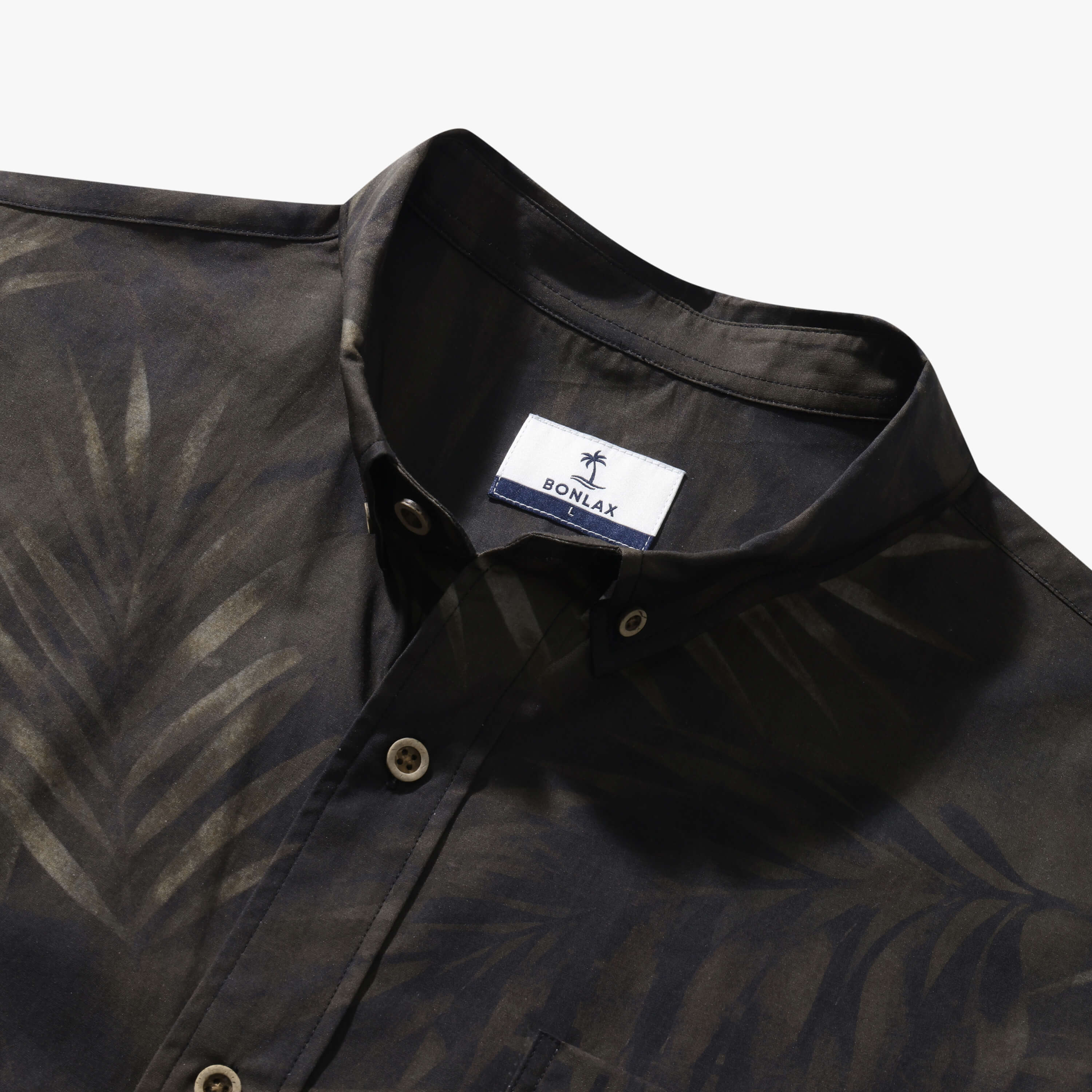 Close-up of the sage green Shadow Palm shirt collar, coconut buttons and tonal palm print